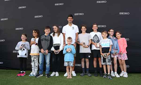 Novak Djokovic presents children with a special watch in honour of his Foundation.
