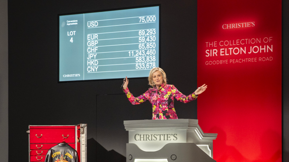 Tash Perrin, Deputy Chairman, Christie’s Americas selling a pair of silver leather tall platform boots © Christie's